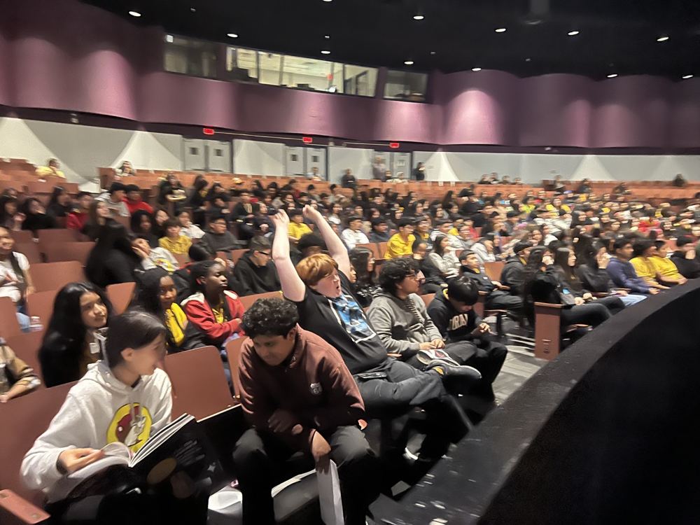 Students gather with raised hands during an LTBB live experience.