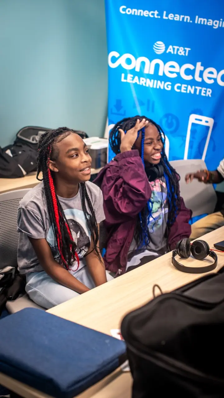 Two students work at an LTBB music technology session with headphones and production equipment.