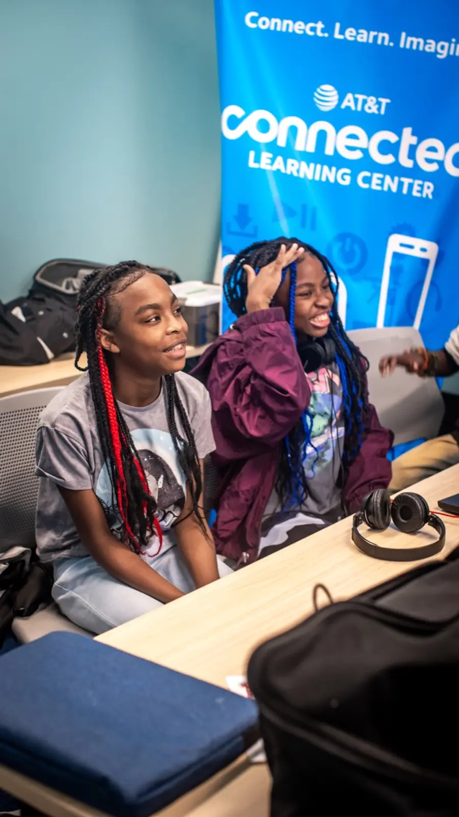 Two students work at an LTBB music technology session with headphones and production equipment.