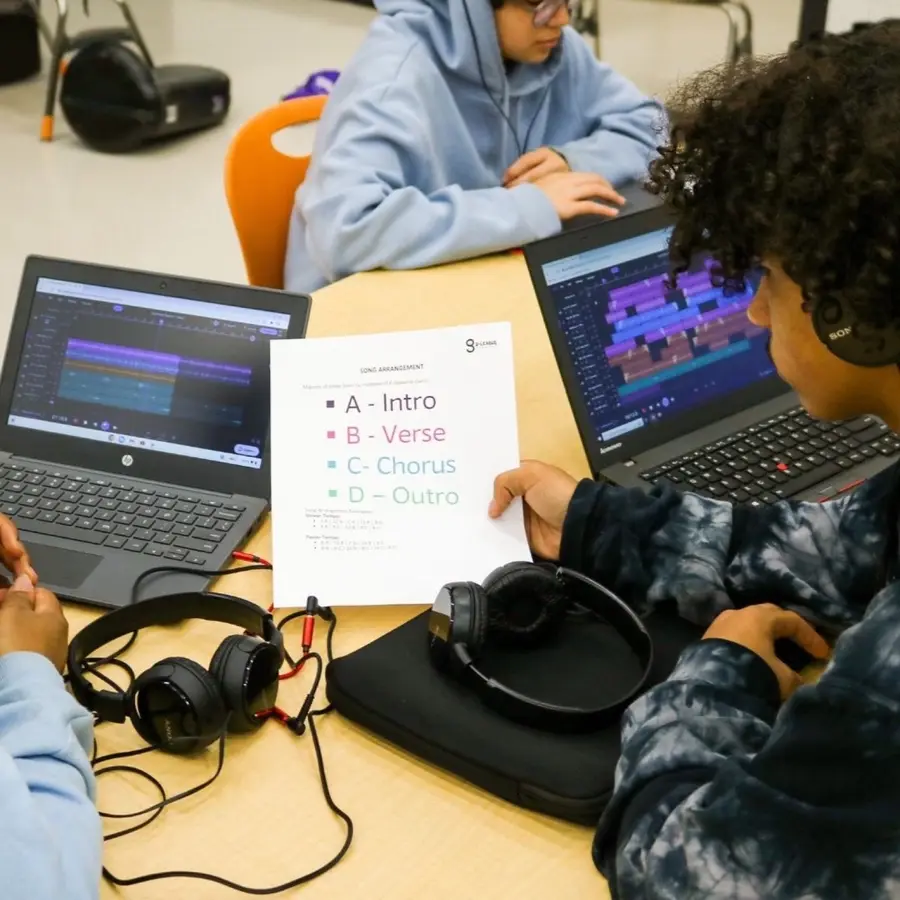 Students collaborate at computers during an IDMT class.