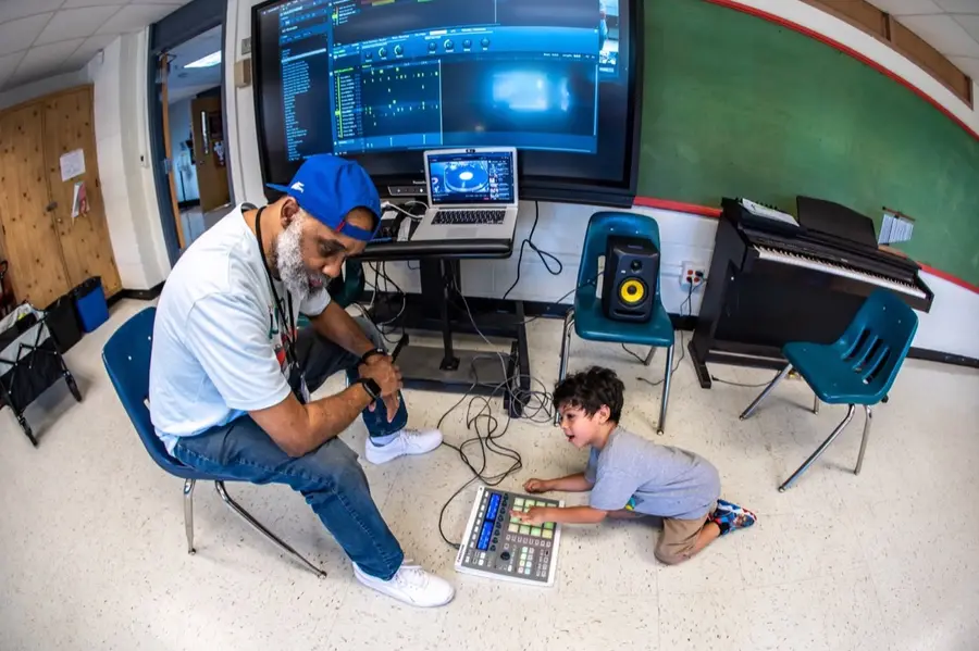 An educator supports learners during an LTBB music technology session.