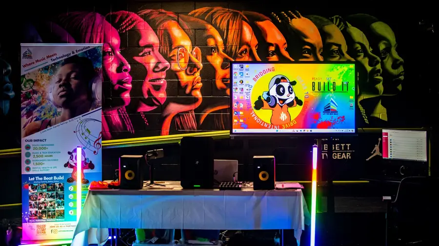 A fully equipped BUILD IT Lab with production workstations, studio monitors, and creative lighting.