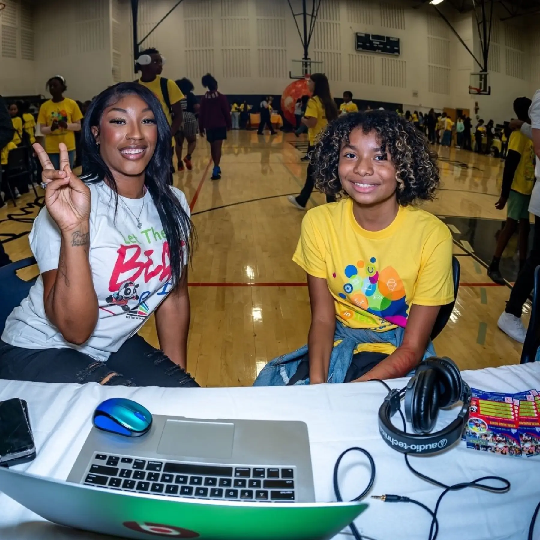 An LTBB mentor and student work together at a laptop during a music program.