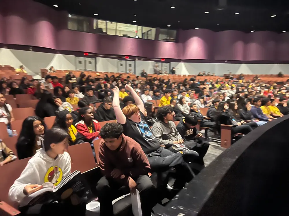 Students gather with raised hands during an LTBB live experience.